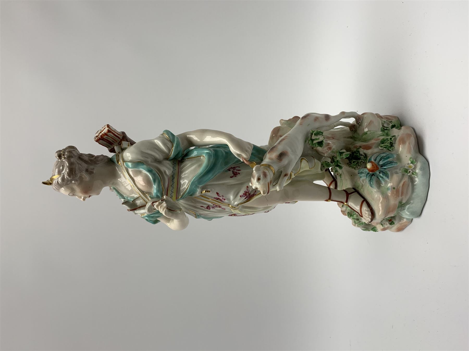 Mid 18th century Derby porcelain figure modelled as Dianna the Huntress, with quiver of arrows upon her back and dog by her side, upon a naturalistically modelled base, with patch marks beneath and collectors labels, H26cm