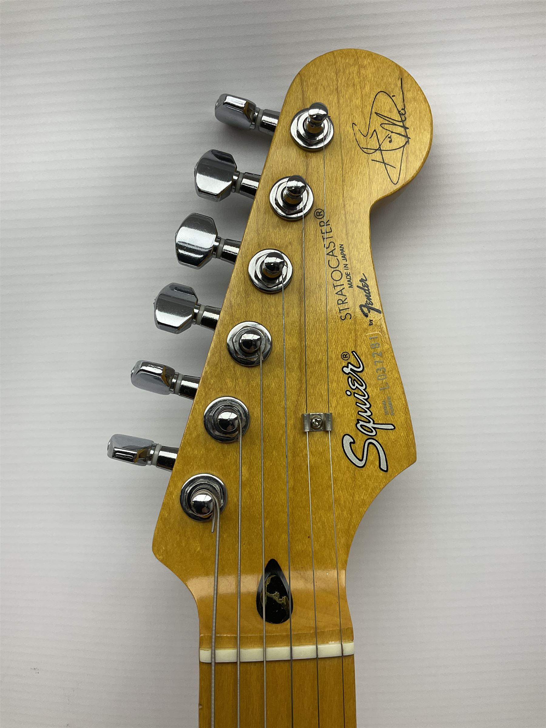 Japanese Squier Fender 'Hank Marvin' Stratocaster electric guitar, c1992, in Fiesta red with tremolo arm and facsimile signature decal; serial no.L037281, L98cm; in hard carrying case.