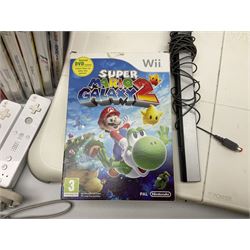 Nintendo Wii console, four controllers with cases and four nunchucks, Wii sensor bar, balance board and dance mat. Guitar hero wireless guitar for Wii and Redoctane wired guitar. Nintendo DS lite handheld gaming console, console and game cases and Guitar Hero Redoctane Guitar Grip. Selection of Nintendo Wii and Nintendo DS lite games to include Super Mario Galaxy, Guitar Hero, Wii Fit, Legend of Zelda games etc. Archos AV400 Series pocket video recorder with accessories, cradle and remote, in three boxes