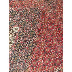 Perisian Bidjar crimson ground rug, within scalloped borders, central pole medallion, the field decorated all over with floral Herati motifs, guarded border decorated with repeating stylised plant motifs and trailing branch 