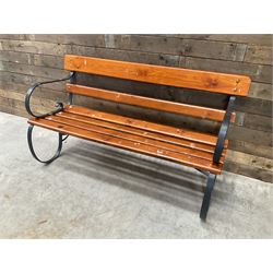 Wrought metal scrollwork and wood slatted garden bench