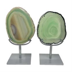 Pair of green agate slices, polished with rough edges raised upon silvered metal stands, H19cm