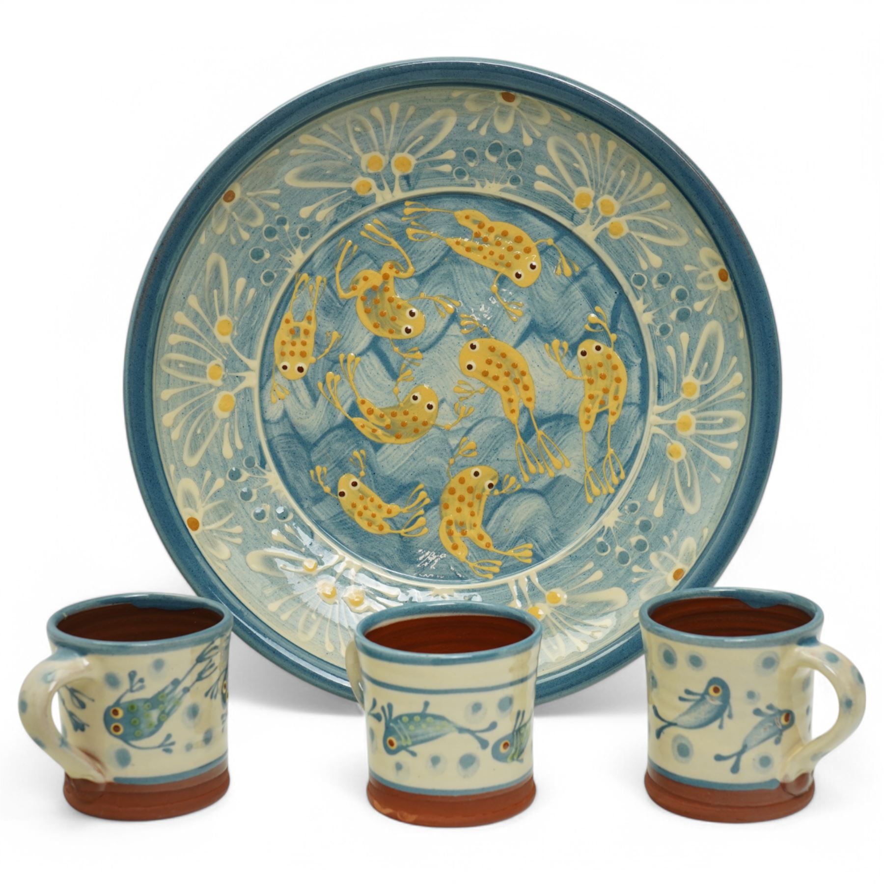 Coxwold studio pottery charger, decorated in a blue and yellow glaze with swimming frogs, together with three mugs with similar swimming fish and frogs, each painted or impressed mark, charger D33cm (4)