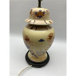 An Oriental style table lamp modelled as a ginger jar, with foliate decoration in blue and red, including fixtures H43.5cm.
