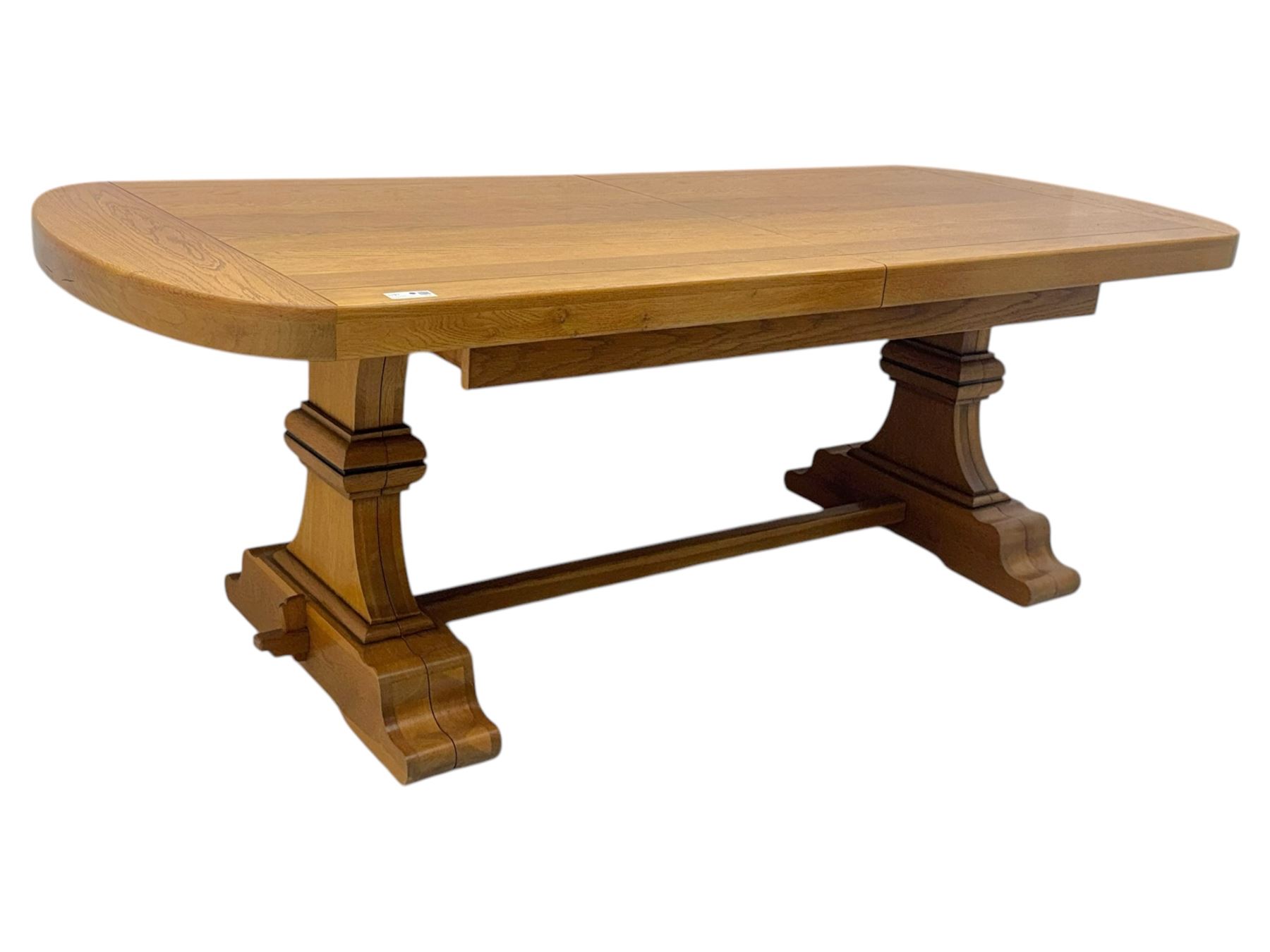 Oak extending dining table with elegant scrolled shaped double pedestal base and scrolled feet; together with a set of eight ladder back chairs with rush seats ((9) table closed 228x95x79cm chairs 106x38x44cm 