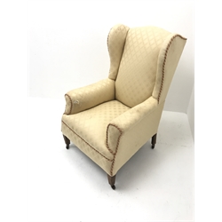 Early 20th century wing back armchair, upholstered in a beige fabric, square tapering supports, W72cm