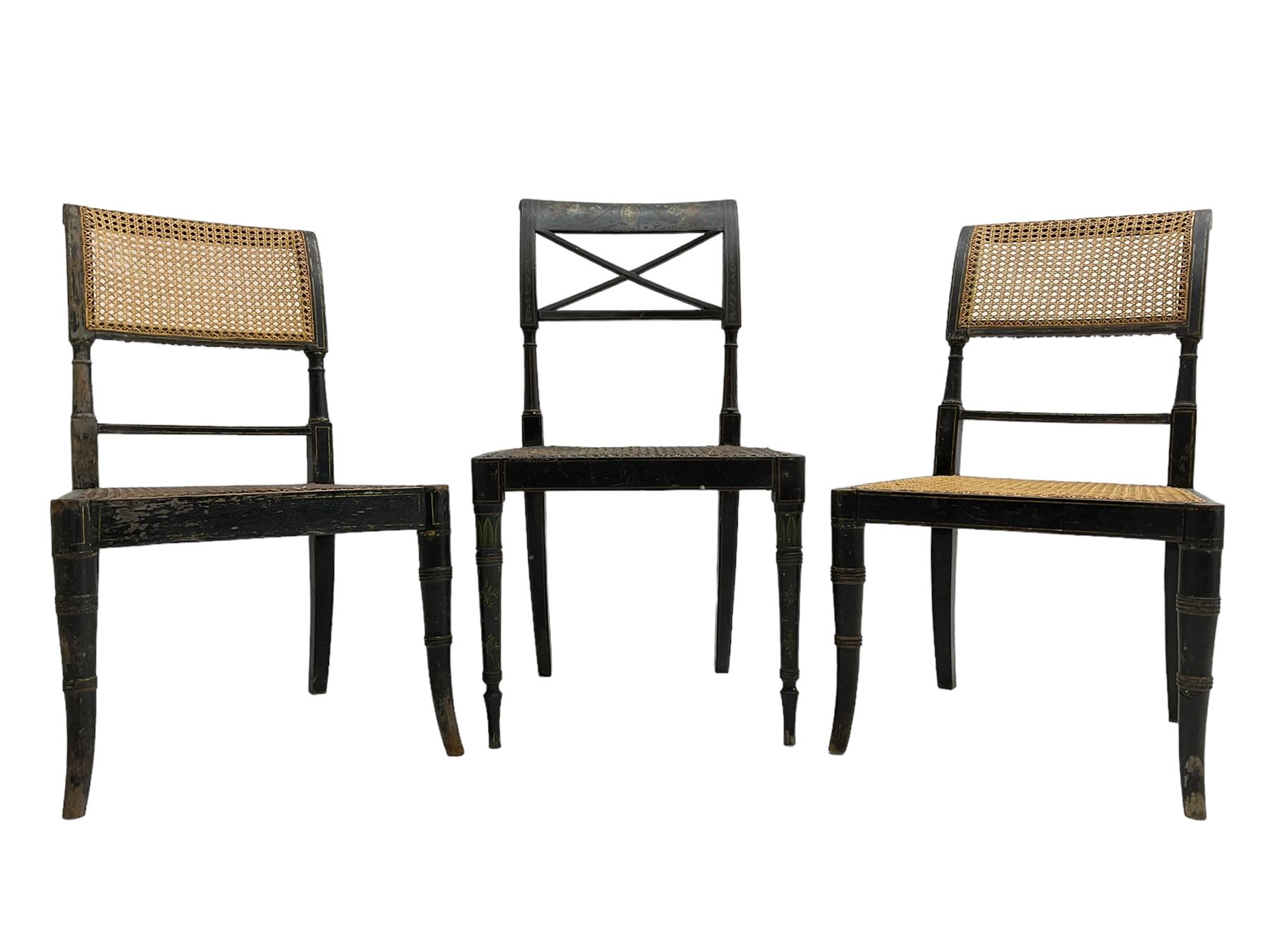 Collection of Regency dining chairs - set of four Regency painted beech dining chairs, with cane seat and back, on collar turned supports with splayed feet (W46cm, H84cm); a pair of Regency ebonised dining chairs (W47cm, H77cm); and a single Regency dining chair, the cresting rail painted with floral cornucopias and central putto vignette, X-frame back over cane seat, on collar turned front supports painted with foliage (W46cm, H84cm) (7)