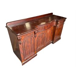 Large Victorian mahogany sideboard, raised back, central banded serpentine frieze drawer over double arched panelled cupboard, flanked by two single cupboards enclosing sliding trays and drawers