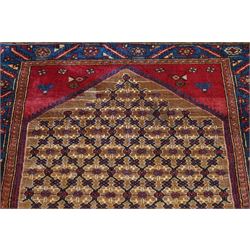 North East Persian Kurdie hand-knotted runner, camel ground with an all-over lattice of rosette motifs linked by angular vines, terminating in a stepped lozenge panel, with a madder red field, spandrels with geometric and zoomorphic devices, indigo main border of angular vines and repeating rosettes, flanked by narrow guard stripes, cotton fringe ends  