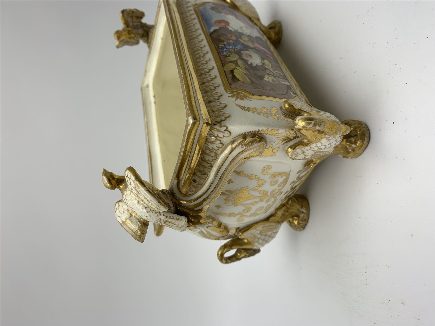 19th century Coalport bough pot, circa 1820, of bombe form, the body with twin handles surmounted by two birds and raised upon four feet modelled as swans, hand painted with two panels depicting an urn of flowers set against a mountainous landscape, the whole heightened in gilt throughout, H13cm L21cm