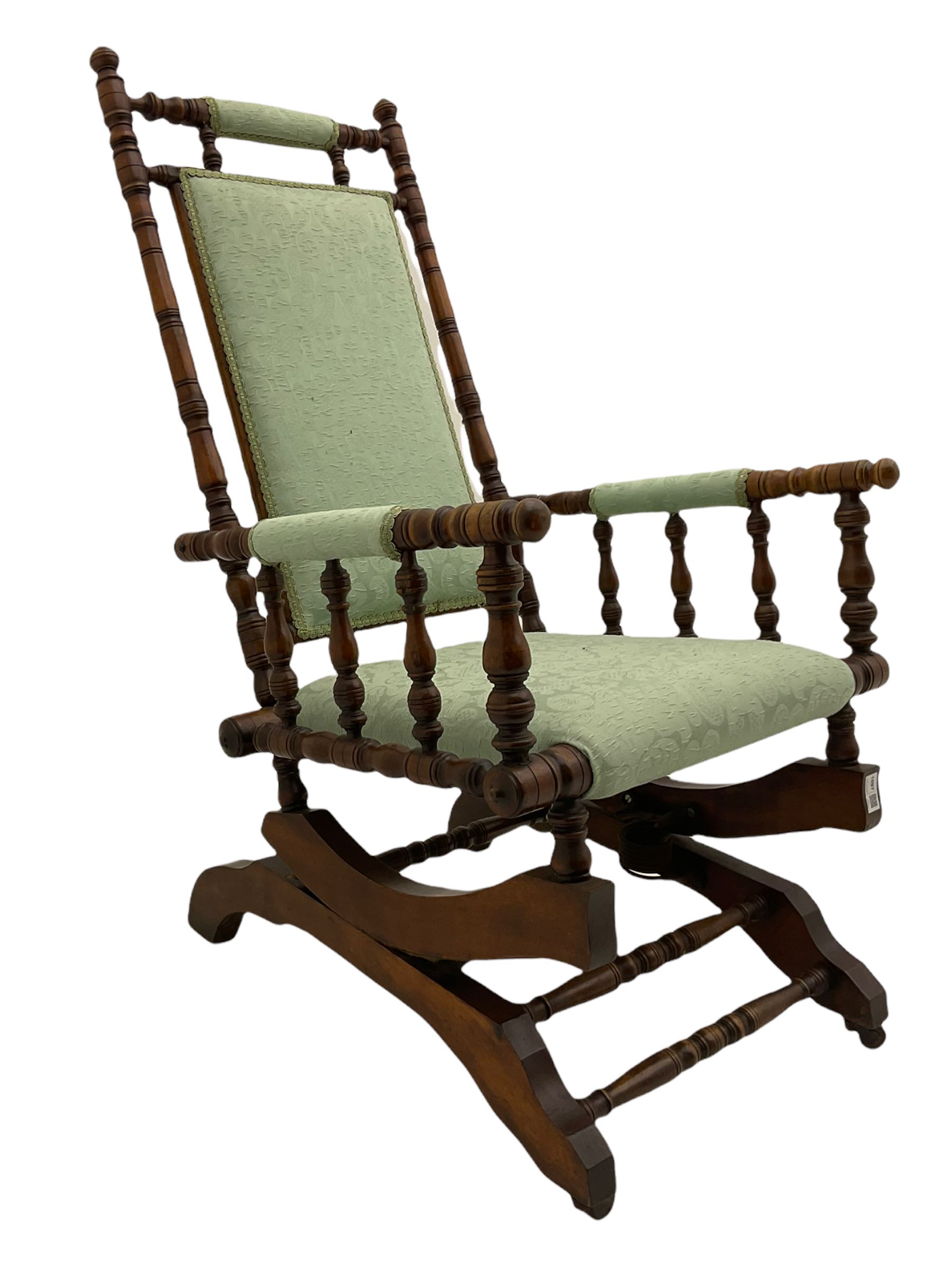 Early 20th century walnut framed American rocking chair, upholstered seat, back and arms