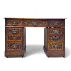 Late 19th century carved oak twin pedestal desk, rectangular top with inset leather writing surface, fitted with nine drawers, carved with scrolling foliate decoration, in three sections