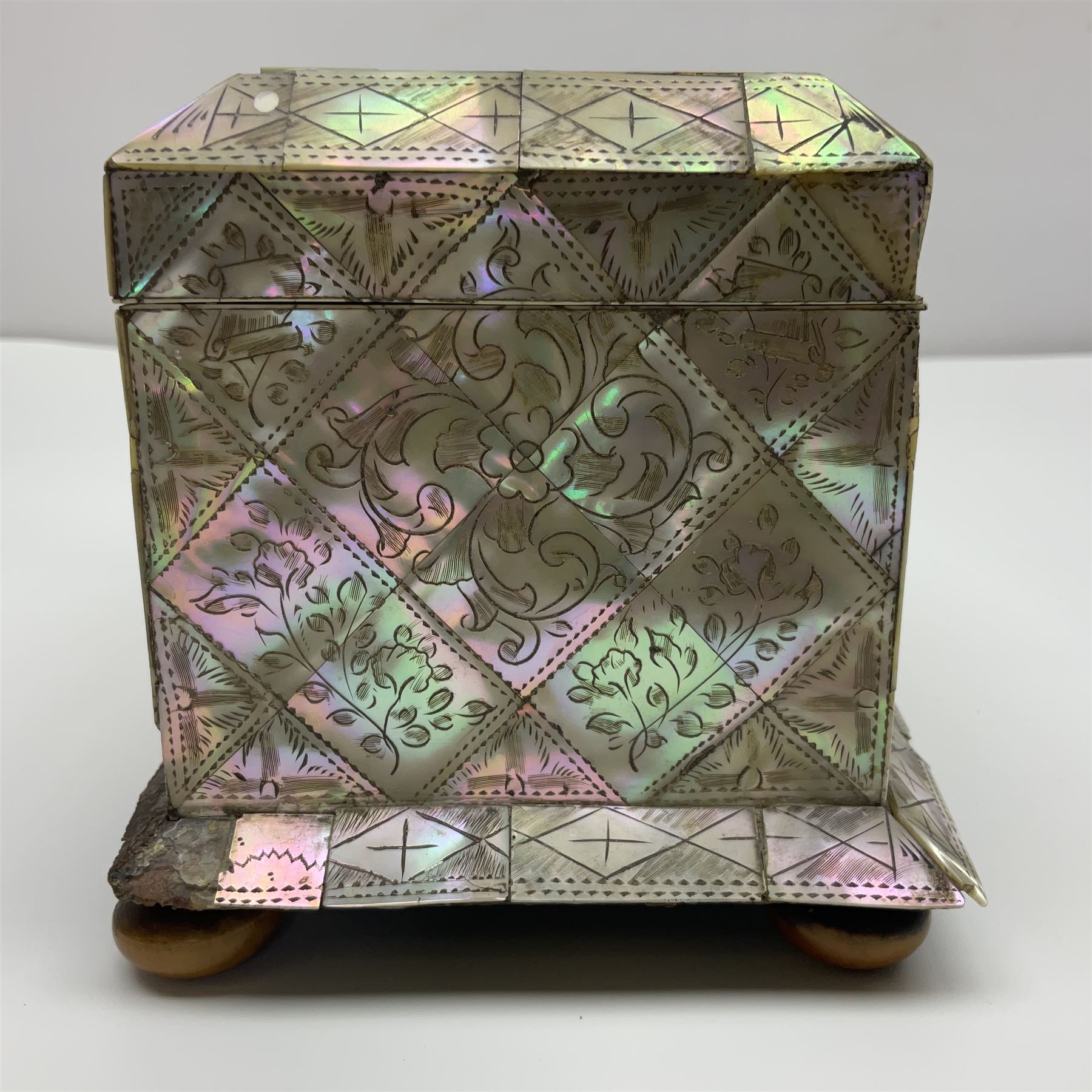 Victorian mother of pearl tea caddy, of rectangular bow-fronted form, the body with floral, bird and geometric engraved mother of pearl panels, white metal shield plaque to the cover inscribed with the initials G.J.A and similar escutcheon, the two division interior with ivory edging and two panelled mother of pearl lids, on four vegetable ivory bun feet L20cm, together with a similar style mother of pearl card case (2) This item has been registered for sale under Section 10 of the APHA Ivory Act