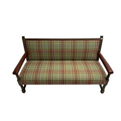 Late 19th century oak framed hall bench, back and seat upholstered in green and red tartan fabric with studwork leather border, arms upholstered in maroon leather, raised on turned supports united by stretcher