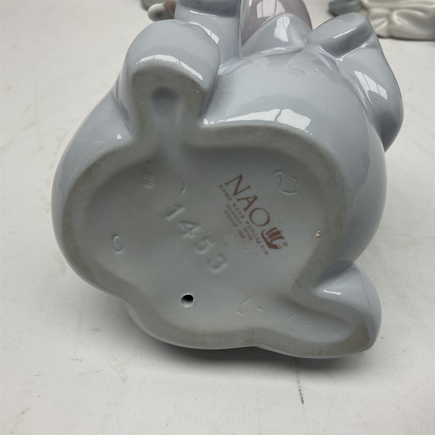 Two Lladro figures, Over the Threshold no 5282 and Prayful Moment no 5500 together with five Nao figures