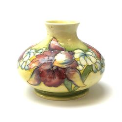 A Moorcroft vase, circa 1950, of squat bulbous form, decorated in the Orchid pattern upon a yellow glazed ground, with impressed and blue painted WM initials for Walter Moorcroft, H10.5cm. 