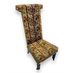 19th century mahogany framed prie-dieu chair, upholstered in red and green patterned fabric, high back with rolled top, standing on turned front supports with castors