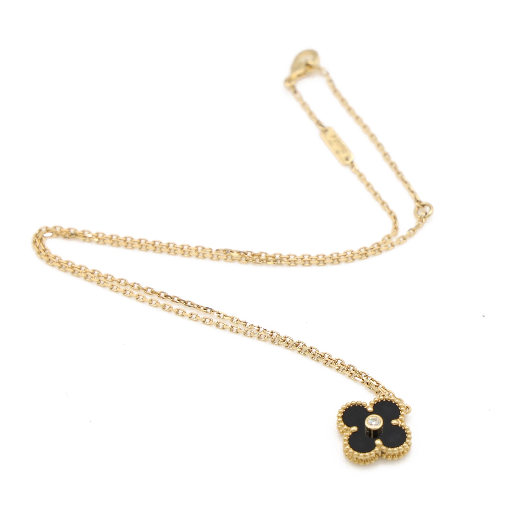 Van Cleef & Arpels Alhambra 18ct gold onyx and diamond necklace, the black onyx quatrefoil pendant set with a single round brilliant cut diamond, to a trace link chain necklace, French assay mark