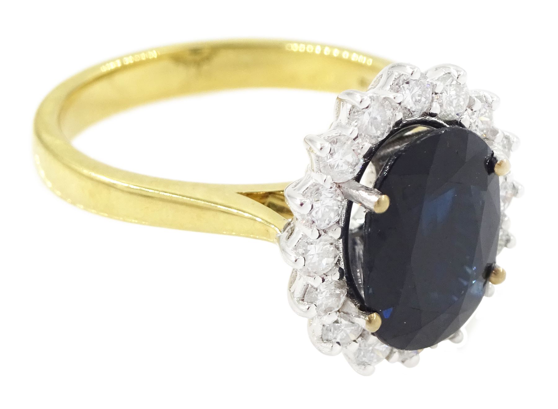 18ct gold sapphire and diamond cluster ring, single oval cut sapphire of approx 2.60 carat, surrounded by sixteen round brilliant cut diamonds, hallmarked, total diamond weight approx 0.45 carat