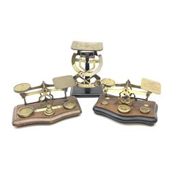 Pair of German Jacob Maul bilateral brass and black enamel postal scales H16cm; and two sets of brass postal scales, each displaying postal rates on serpentine hardwood bases inset with various brass weights (3)