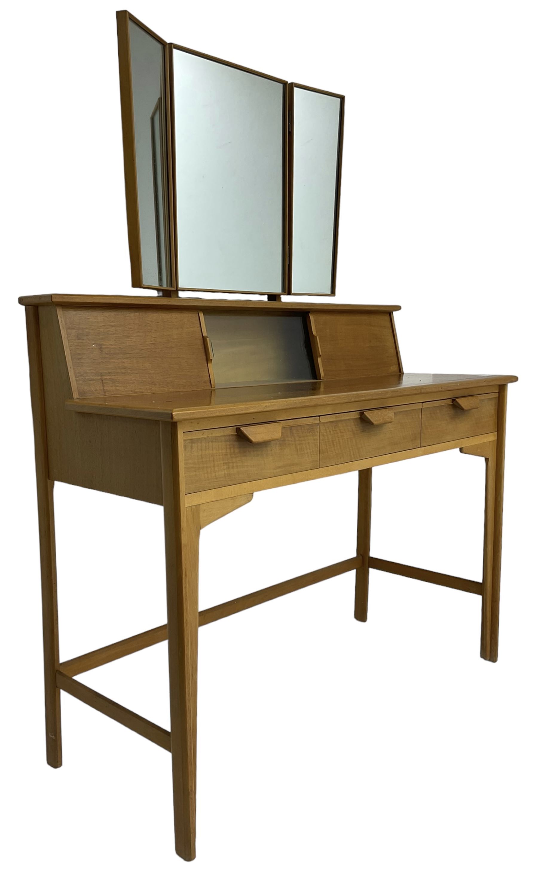 Heals of London - 1950s walnut and beech dressing table, raised triple mirror back over trinket compartments enclosed by sliding doors, above three drawers, on tapering supports