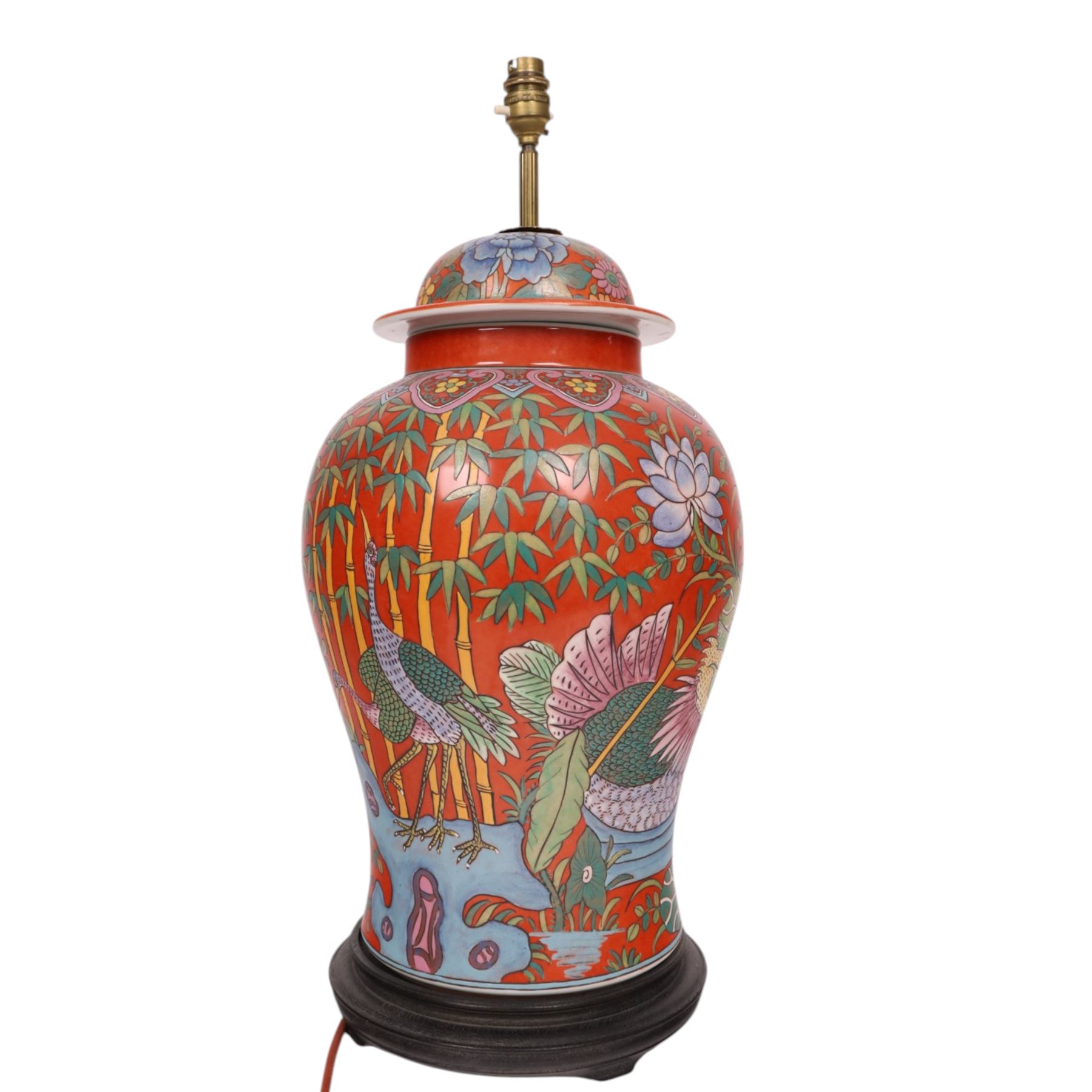 Table lamp of baluster form, decorated with ducks and lilies upon a red ground upon a circular wooden base, H64cm