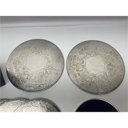 Set of eight silver plated placemats, each of circular form with engraved scroll and floral decoration, including two larger and six smaller examples, largest D23cm, in fitted case 