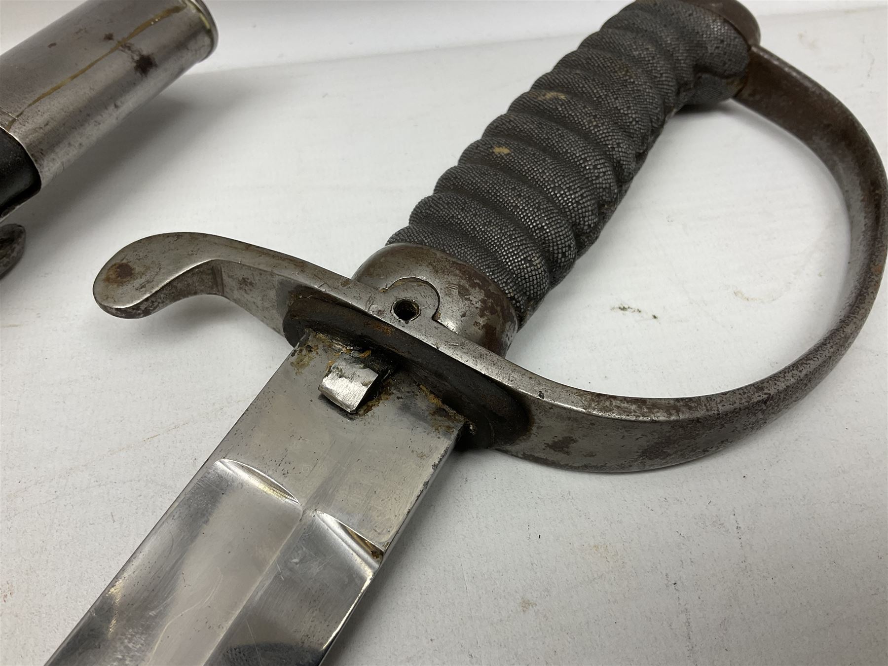 Mid-19th century Custom’s officer/Constabulary sidearm, with plain 60.5cm slightly curving fullered blade double edged at tip,  steel knucklebow and downswept quillon, stepped pommel and ribbed fishskin grip; in leather covered scabbard with steel locket, frog stud and chape L76cm overall