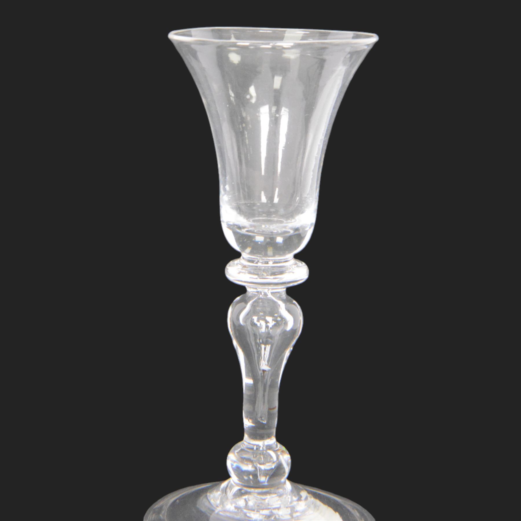 Mid 18th century wine glass, circa 1730-1740, with bell shaped bowl upon an inverted baluster stem with internal tear and basal knop, upon conical folded foot, H15cm