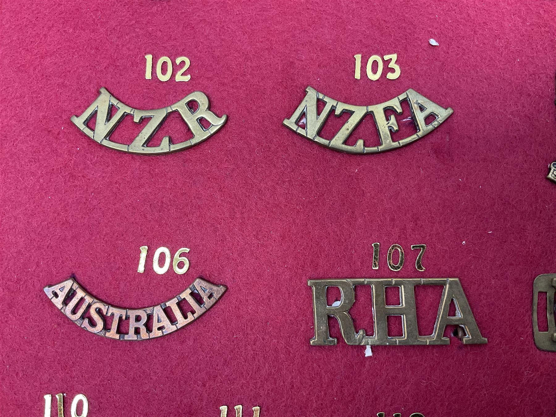 Forty glengarry and cap badges and shoulder titles including Gordon Highlanders, Canada and Canadian Field Artillery, New Zealand Field Artillery and Rifle Regiment, Shropshire Light Infantry, 14th/20th Kings Hussars, 17th Lancers, Northamptonshire Yeomanry, Royal Lincolnshire, Special Air Service, 19th Alexandra P.W.O. Hussars etc; mounted on two boards for display (2)