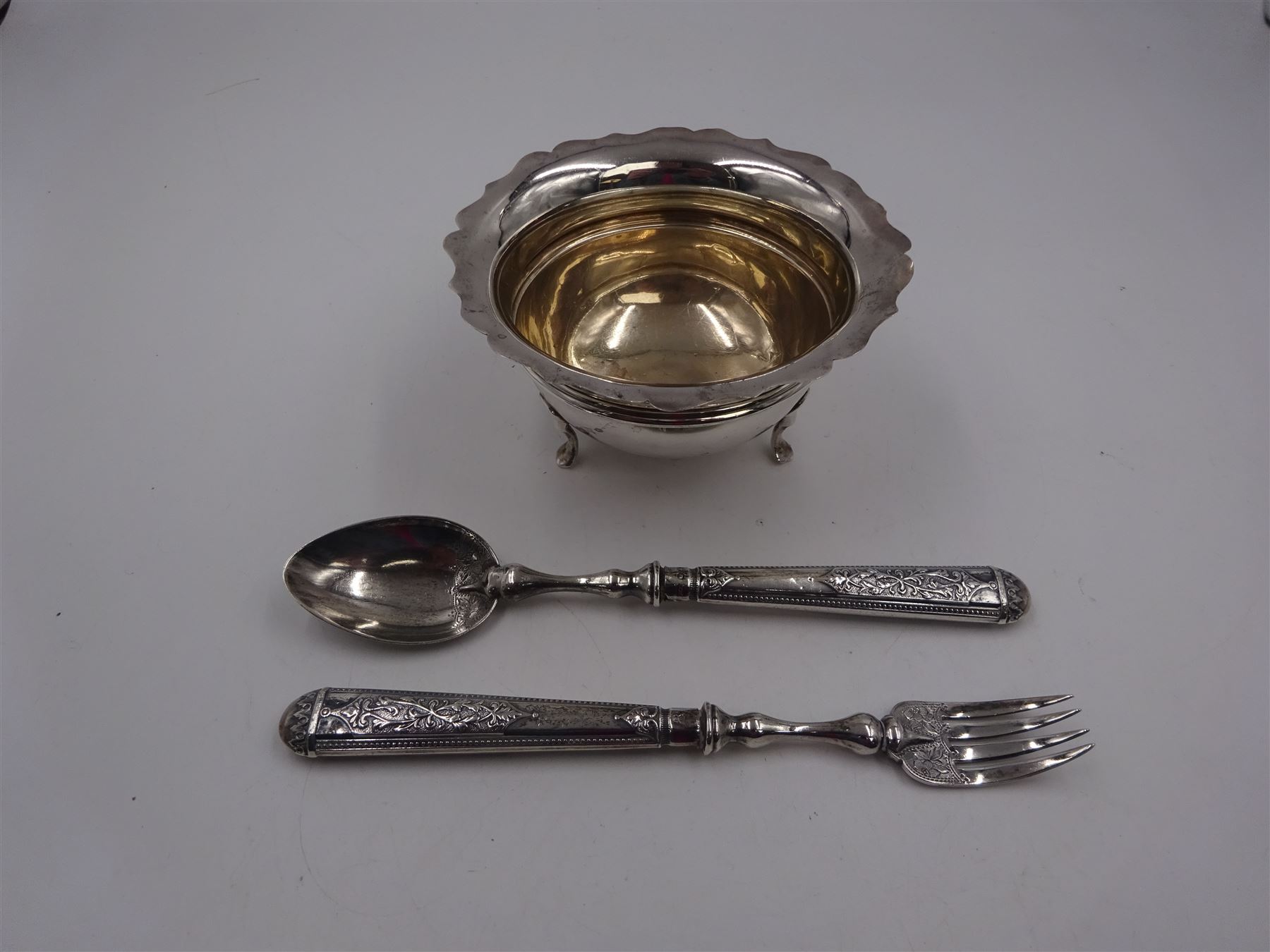 1930s silver open sucrier, of circular form with girdle, with shaped rim and upon three pad feet, hallmarked Birmingham 1931, together with silver fork and spoon set, decorated in relief with foliate pattern to handles, hallmarked William Devenport, Birmingham 1896 to blades and Sheffield 1896 handles