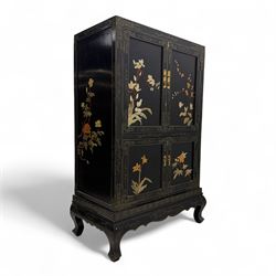 Late 20th century Chinoiserie black lacquer cabinet, the rectangular body decorated with hand-painted floral and foliate motifs in polychrome and gilt, fitted with four panel doors enclosing shelved interior, on shaped apron and stylised cabriole supports with gilt scrollwork