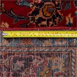 Two Persian rugs, the larger with a crimson field decorated with three linked indigo medallions amongst flowering tendrils, shaped floral spandrels and an indigo palmette border, (161cm x 129cm), the smaller with a crimson field centred by an ivory rosette amongst stylised flowering plants, within a dark floral border, (114cm x 79cm) (2)