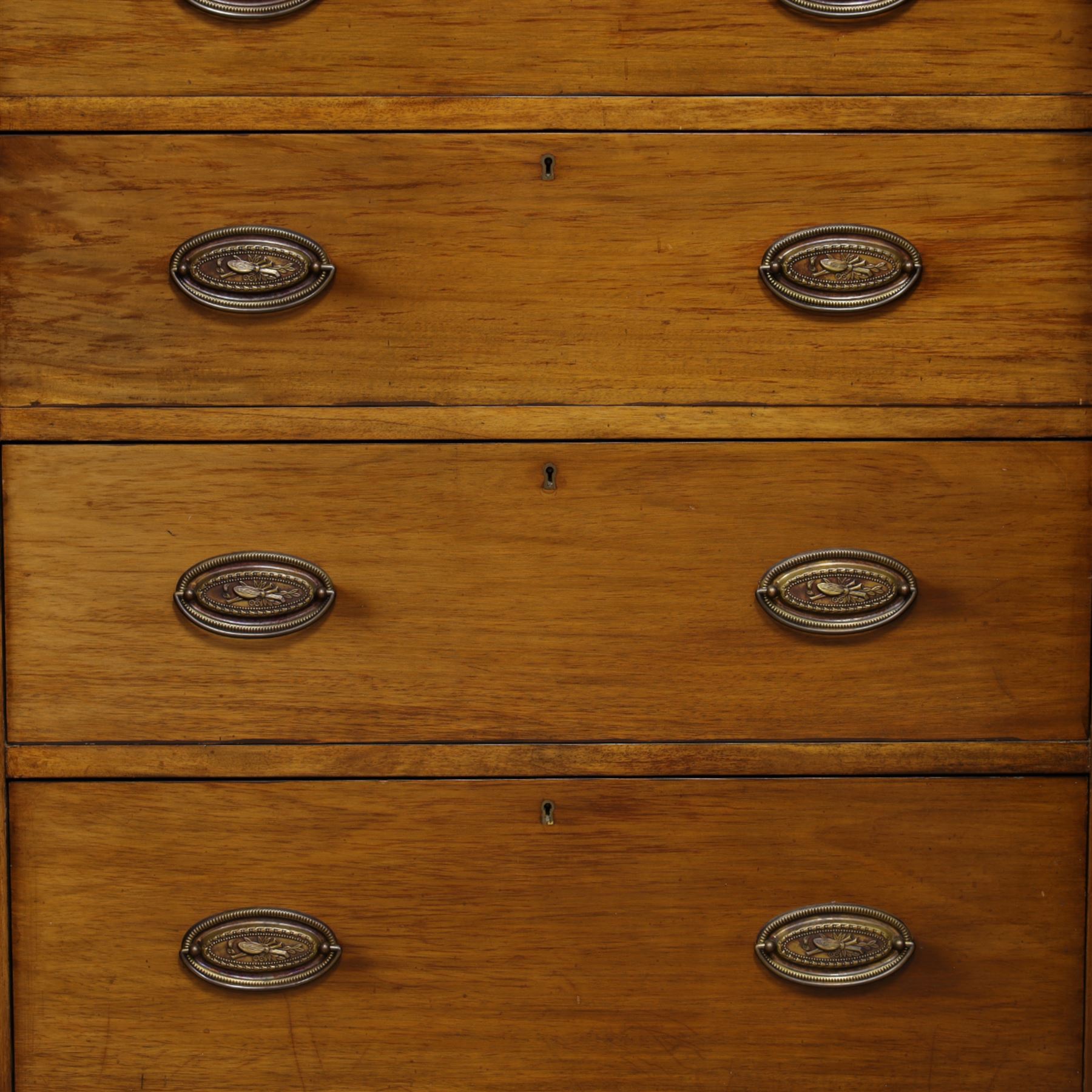 19th century mahogany triple wardrobe, moulded cornice above a central cupboard door enclosing shelves interior, flanked by full height panelled doors with clothes rails in each, the centre fitted with four graduated drawers with oval brass handles, on a moulded plinth base