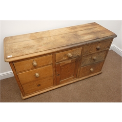  Early 20th century Pine dresser base, seven graduating drawers, single cupboard door, W135cm, H74cm, D47cm  