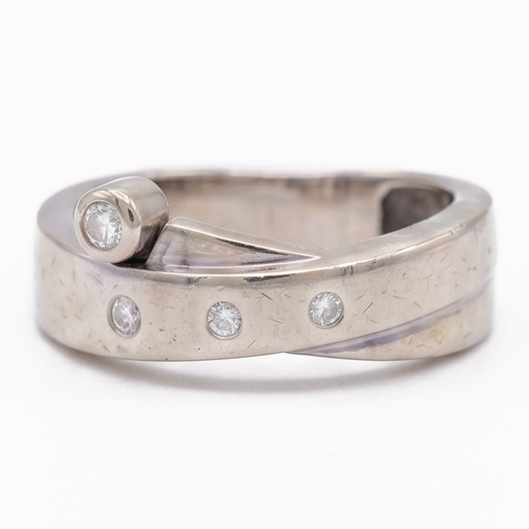 14ct white gold four stone diamond crossover ring, rubover and bezel set with four round cut diamonds, stamped 585