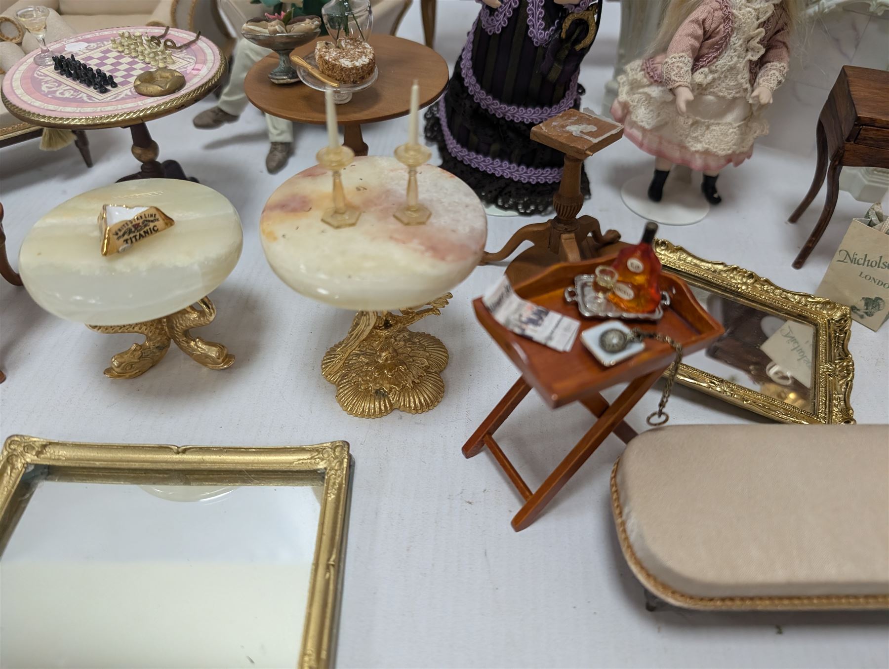 Dolls house furniture, including sofa, chairs, foot stools, fireplace, sideboards, five figures, mirrors, paintings and accessories