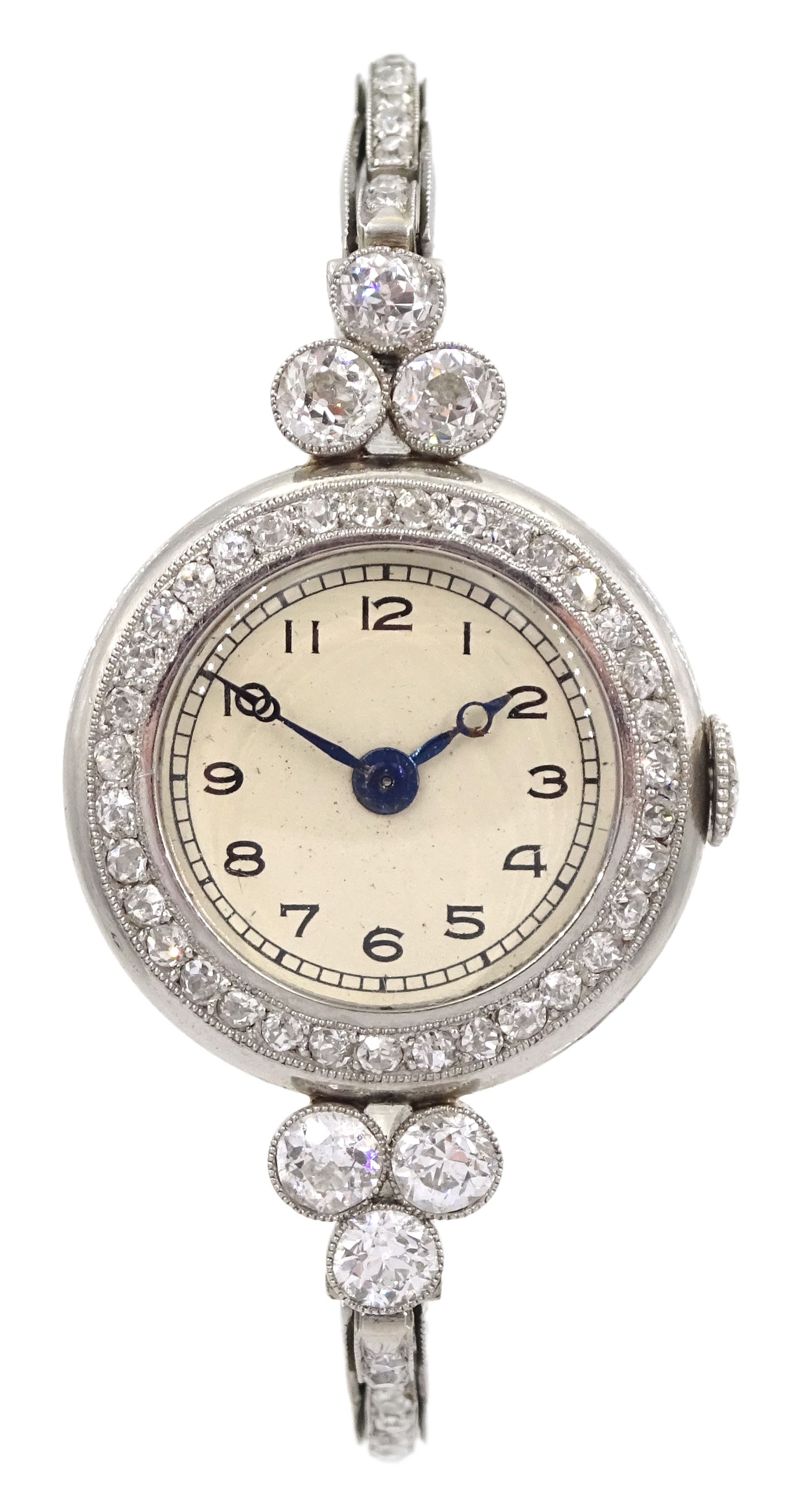 Platinum Art Deco milgrain set diamond manual wind lever wristwatch, cream enamel dial with Arabic numerals, diamond set bezel, the case spaced by two groups of three diamonds of approx 0.20 carat each, to a platinum expanding link bracelet, the first two links on each side set with diamonds, back case stamped 8942 and initialled JF with Fleur de Lys mark sitting between the letters
