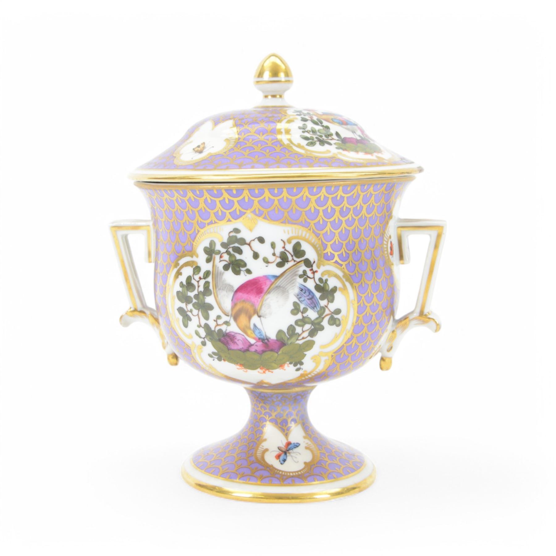 19th century twin handled cup and cover, the pedestal cup decorated with panels of exotic plumed birds in the manner of Giles, against a purple and gilt scale ground, the cover similarly decorated, H19cm