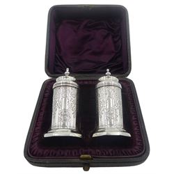 Pair of Victorian silver pepperettes, the bodies of cylindrical form with foliate bright cut engraved decoration and engraved monogram, supporting domed covers with urn finials, upon octagonal bases, hallmarked John Aldwinckle & Thomas Slater, London 1890, contained within a fitted case with purple silk and velvet lined interior, approximate total silver weight 1.86 ozt (58 grams)