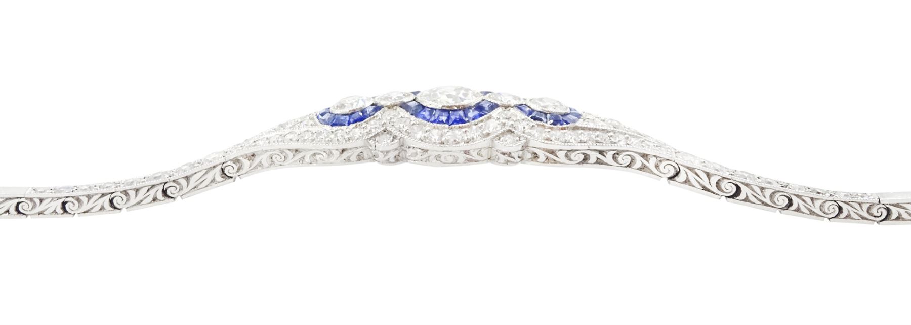 Art Deco platinum diamond and sapphire target design bracelet, five old cut diamonds, surrounded by calibre cut sapphires and old cut diamonds, all milgrain set, to a graduating old cut diamond and polished articulated rectangular link bracelet, the sides with engraved foliate decoration, French import mark, principal diamond approx 0.45 carat