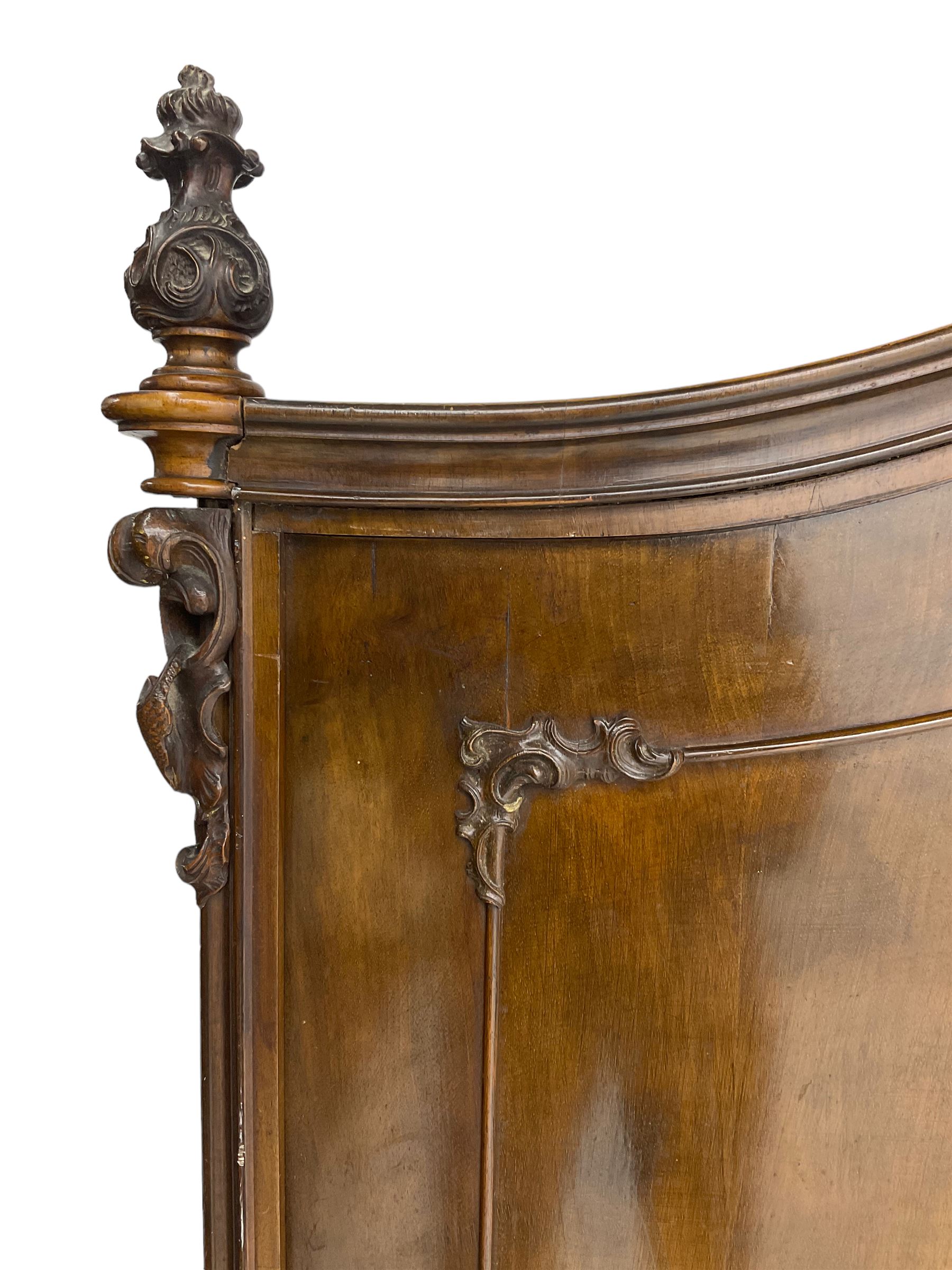 Early 20th century Italian walnut armoire wardrobe, the pierced and scrolling pediment carved with acanthus leaf detail, flanked by two scrolling cartouche with matching corbels below, the two panelled doors with applied carved rinceaux slips, with a central spiral turned upright, enclosing single shelf and hooks, raised on scroll feet