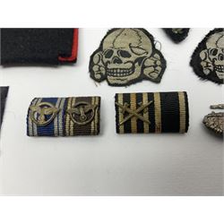 Collection of eleven German metal and cloth badges and uniform buttons including driver's badge, two 'SS' fabric skulls, private's shoulder tabs, Police cloth badge, tank destruction badge, medal bars and ribbon etc; most WW2 period