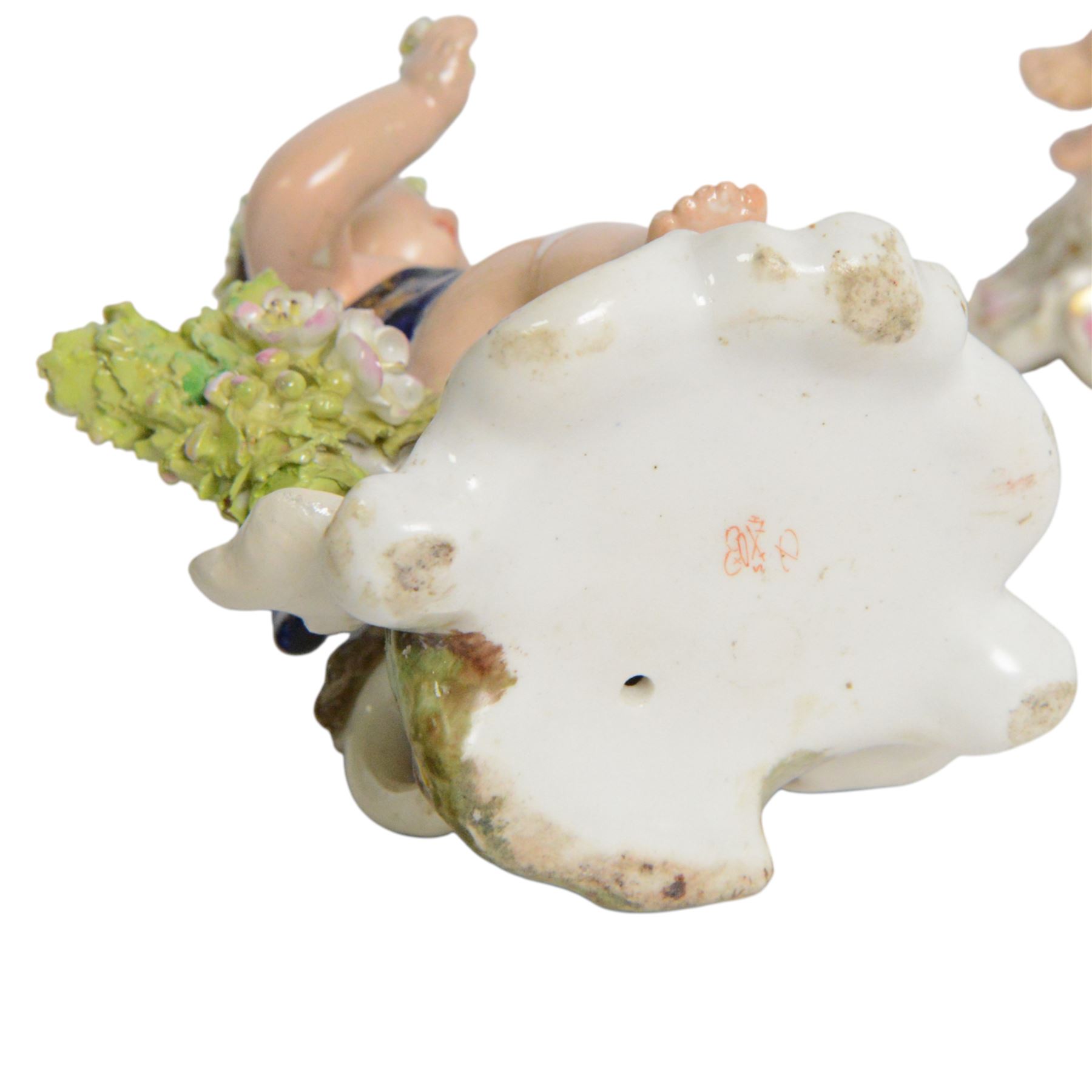 Pair of 19th century Stevenson and Hancock Derby figural chambersticks, each modelled as a seated cherub with arm around foliate encrusted sconce, marked beneath, H18cm