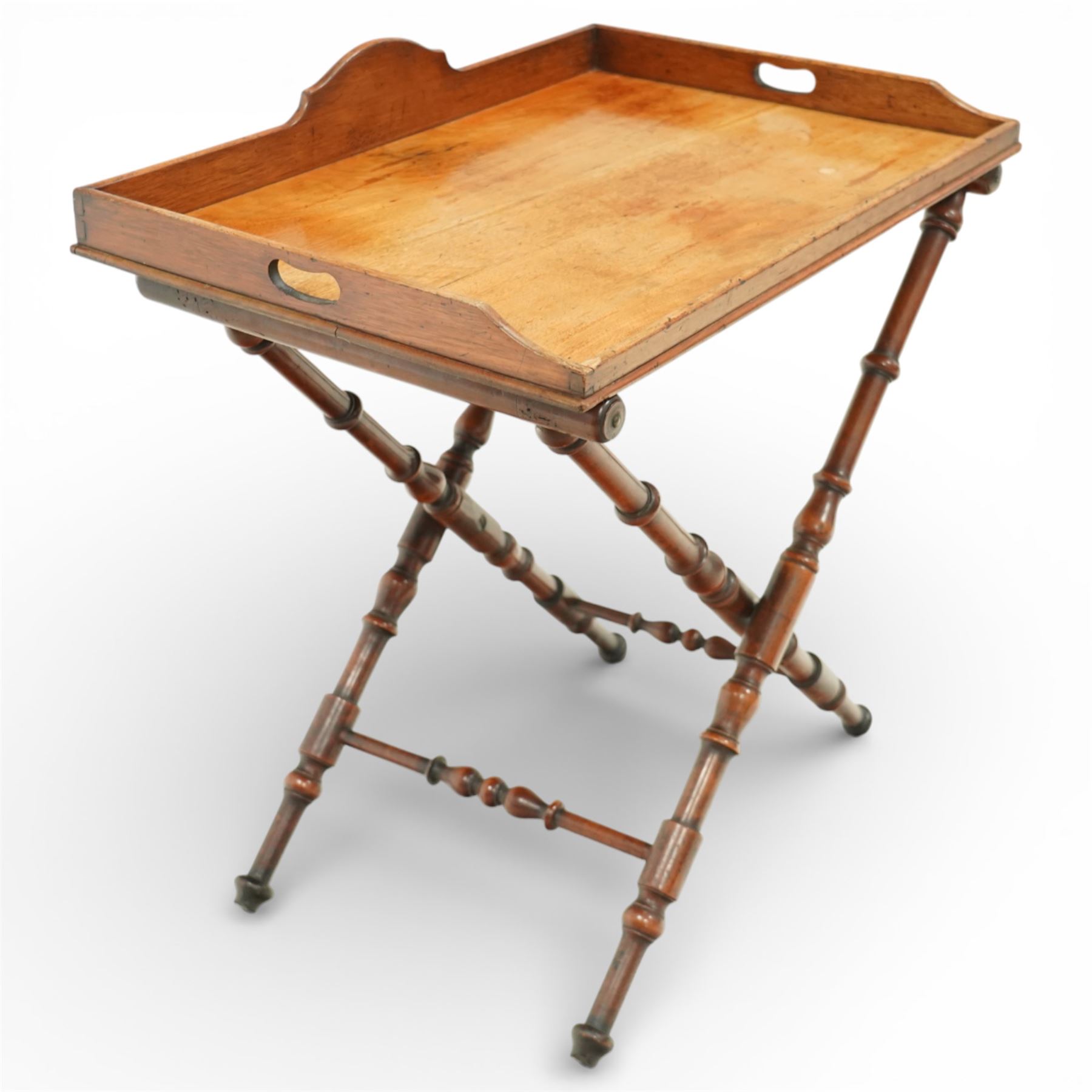 19th century coaching table, the rectangular tray top with shaped gallery and cut out carrying handles, raised on a folding X frame stand with turned supports and stretcher rails