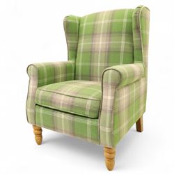 Contemporary green tartan upholstered wingback armchair, with scroll arms and loose seat cushion, raised on turned beech front supports with brass castors