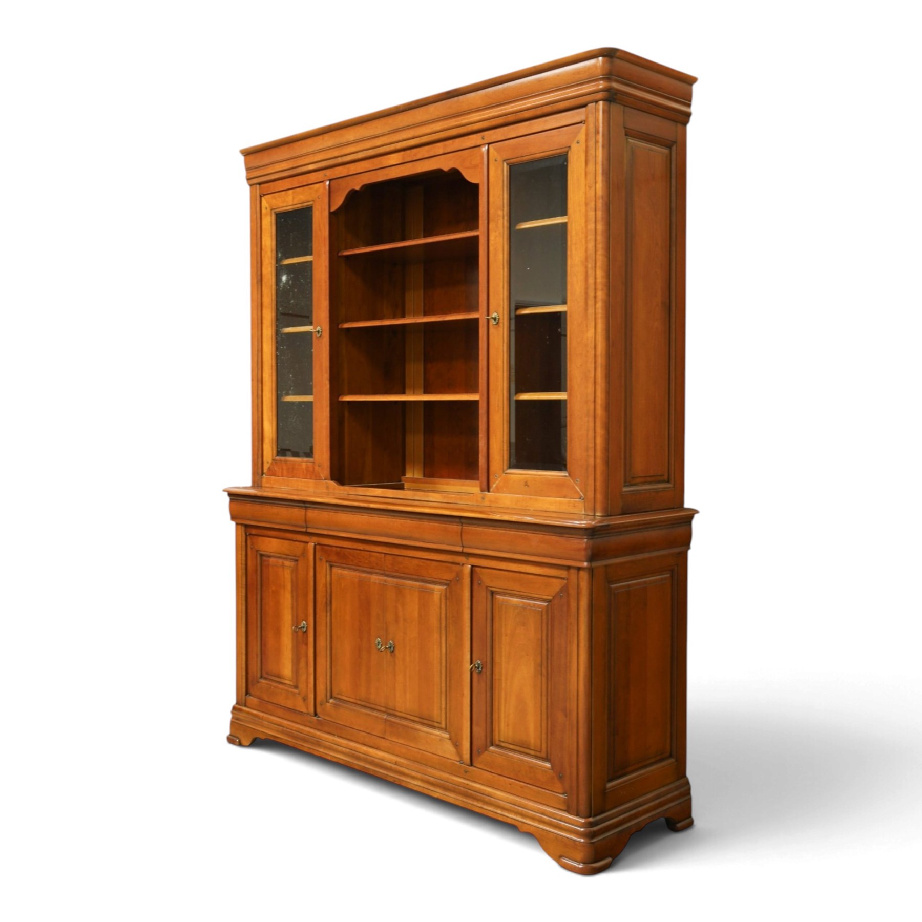 Barker & Stonehouse - large cherrywood bookcase cabinet, the moulded cornice above two glazed doors flanking an open central section, the base with three cushion drawers over four lockable panelled cupboard doors, raised on bracket feet