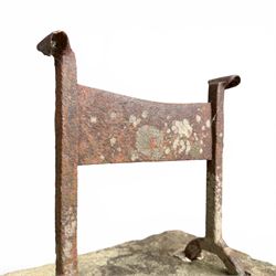19th century cast iron boot scraper, mounted on a rectangular hewn stone slab base, with scrolled twin upright supports and scraper bar, in weathered finish