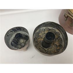 Four Victorian copper moulds, together with a graduating set of copper pans with wooden handles and finials to covers, largest pan 
