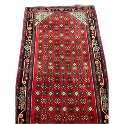 North West Persian crimson ground Bidjar runner, the field decorated with rows of stylised flower head motifs, indigo ground border with trailing design decorated with plant motifs, within guard stripes